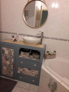 ein Badezimmer mit Waschbecken, Badewanne und Spiegel in der Unterkunft Maison de centre-ville in Le Mans