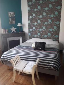 ein Schlafzimmer mit einem Bett und zwei weißen Stühlen in der Unterkunft Maison de centre-ville in Le Mans