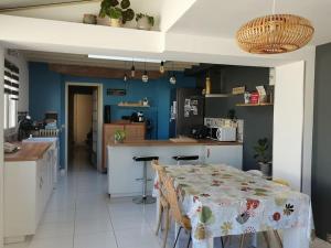 eine Küche mit einem Tisch und eine Küche mit blauen Wänden in der Unterkunft Maison de centre-ville in Le Mans