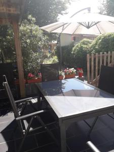 ein Tisch und Stühle auf einer Terrasse mit einem Sonnenschirm in der Unterkunft Maison de centre-ville in Le Mans + 9 Fotos