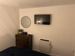 a bedroom with a mirror and a dresser and a tv at THE ARCHERS in Glastonbury +5 photos