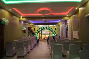 Hotel Virasat Retreat في باتنا: غرفة مع صفوف من الكراسي في غرفة مع أضواء أرجوانية
