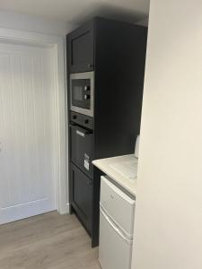uma cozinha com um frigorífico preto e um micro-ondas em THE ARCHERS em Glastonbury