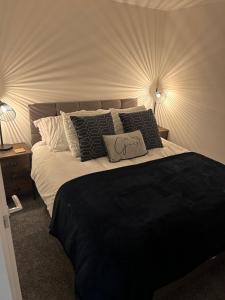 een slaapkamer met een groot bed met zwart-witte kussens bij THE ARCHERS in Glastonbury