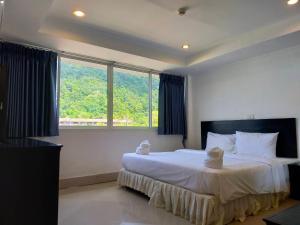 a bedroom with a large bed with a large window at KOH CHANG LUXURY HOTEL in Ban Map Khangkhao