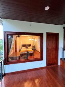 ein Schlafzimmer mit einem Bett in einem großen Fenster in der Unterkunft Marari Xavier's Inn in Alappuzha