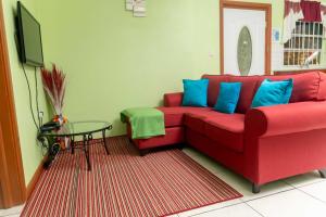 a red couch with blue pillows in a living room at Bougainvillea Apartments 2 in Castries