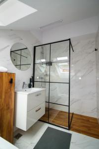 Un baño con ducha de cristal y lavabo. en Forest Boutique, en Piteşti 157 fotos más