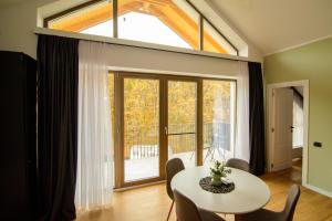 Una sala de estar con una mesa y una gran ventana. en Forest Boutique, en Piteşti
