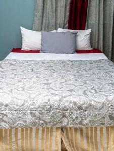 uma cama com uma colcha branca e almofadas em Bougainvillea Apartments 2 em Castries