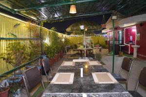 Hotel Virasat Retreat في باتنا: مطعم بطاولة وكراسي ونباتات