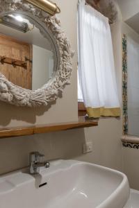 a bathroom with a white sink and a mirror at Old Bridge large and unique artful apartment with elevator in Florence