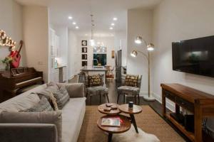 a living room with a couch and a tv at The Dawson - Gulch Elegance, Green Rooftop Retreat in Nashville