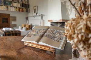 a book sitting on top of a wooden table at Old Bridge large and unique artful apartment with elevator in Florence