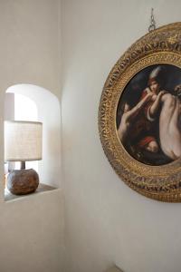 a painting hanging on a wall next to a lamp at Old Bridge large and unique artful apartment with elevator in Florence