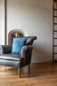 a leather chair with a blue pillow in a room at Old Bridge large and unique artful apartment with elevator in Florence