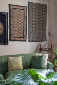 a green couch sitting in a living room with pillows at Old Bridge large and unique artful apartment with elevator in Florence