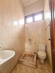 La salle de bains est pourvue d'une baignoire, de toilettes et d'un lavabo. dans l'établissement Homestay Pesona Sintuk Bontang A9, à Bontang