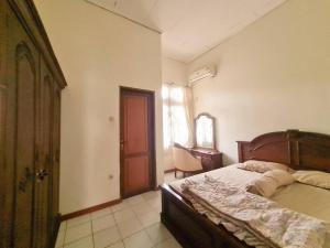 a bedroom with a bed and a dresser and a window at Homestay Pesona Sintuk Bontang A9 in Bontang