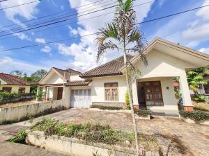 a house with a palm tree in front of it at Homestay Pesona Sintuk Bontang A9 in Bontang