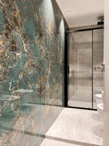 a bathroom with a glass shower and a toilet at YLS Luxury Suites 2 in Milan