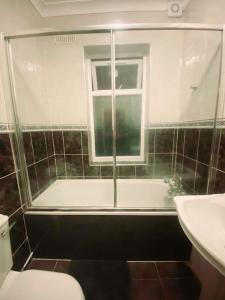 baño con bañera, aseo y ventana en Gravesend Spacious 2 bedroom Apartment - 2 mins to Town Centre and Train Station, en Kent