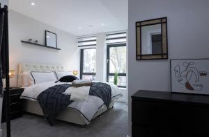 a white bedroom with a bed and a mirror at Chapel House in London