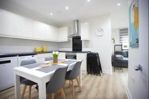 a kitchen with a white table and chairs in a room at Chapel House in London