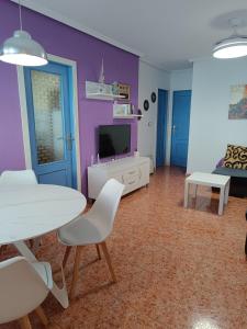 a living room with a table and chairs and a tv at Alhambra Apartments in Gran Alacant