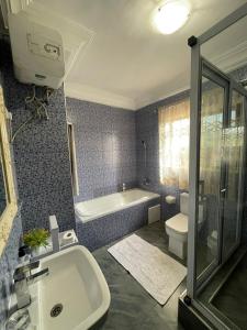 Kokrobite的住宿－Perriman Hotel，带浴缸、盥洗盆和卫生间的浴室
