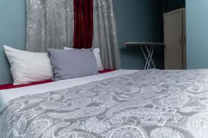 una camera da letto con letto, lenzuola e cuscini bianchi di Bougainvillea Apartments 2 a Castries