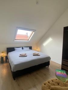 Woning Oostende - Oosteroever NIEUW في أوستند: غرفة نوم عليها سرير وفوط