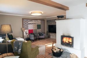 ein Wohnzimmer mit einem Kamin und einem Sofa in der Unterkunft Gipfelkönig in Bayrischzell