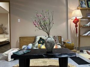 Hiên Cát homestay في هوى: مزهرية على طاولة في غرفة المعيشة