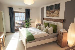 Schlafzimmer mit einem Bett mit grünen und weißen Kissen in der Unterkunft Gipfelkönig in Bayrischzell