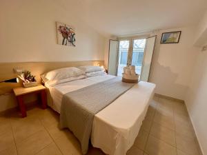 ein Schlafzimmer mit einem großen weißen Bett und einem Fenster in der Unterkunft Sperlonga Paradise Apartment Complex in Sperlonga