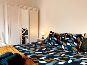 a bedroom with a bed with a colorful comforter at Le Soleil Parisien in Villejuif
