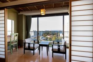 una sala da pranzo con tavolo, sedie e una grande finestra di Shirahama Onsen Kisyu Hanto a Shirahama