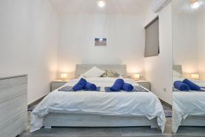 Un dormitorio con una cama grande con almohadas azules. en Two Bedroom Apartment in Xemxija, St. Paul's Bay en St. Paul's Bay