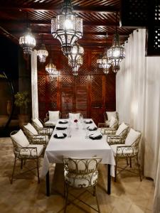 comedor con mesa, sillas y lámparas de araña en Riad des Fragrances dar el Bacha en Marrakech