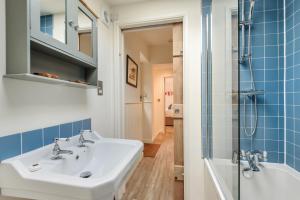 ein Bad mit einem Waschbecken und einer Dusche in der Unterkunft Cottage in Tranquil Hamlet in Salcombe