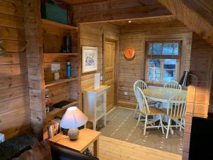a room with a table and chairs in a cabin at Horsey Reach Lodge in Stanley