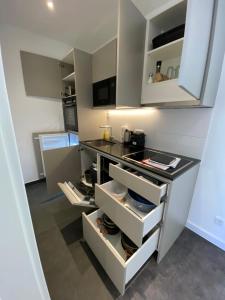 a kitchen with white cabinets and a black counter top at 1-LIVING Apartment Houses in Nuremberg