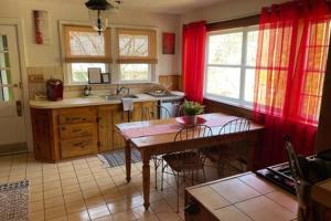 cocina con cortinas rojas y mesa con sillas en Catskills Cabin with Hot Tub near Skiing, en Shandaken