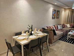 uma sala de estar com uma mesa e um sofá em Luxury Living 3 Bedroom Apartment with Beautiful Balcony Space, Casablanca em Casablanca