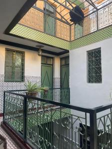 マラケシュにあるHOTEL EL AMALの緑のドアが付いたバルコニー付きの家