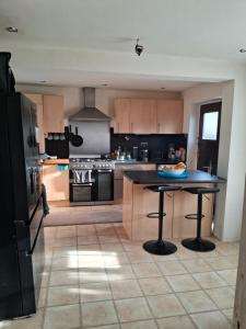 a large kitchen with a black island in the middle at 4 mereside walk in Manchester