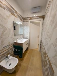 ein Badezimmer mit einem weißen Waschbecken und einem Spiegel in der Unterkunft Marta's Home in Molfetta