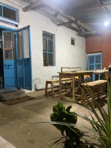 ハンピにあるPeshagar Guest Houseの木製テーブルと青いドア付きのパティオ