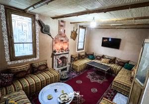 a living room with couches and a fire place at Villa Mouloud réservée aux familles in Arrougou